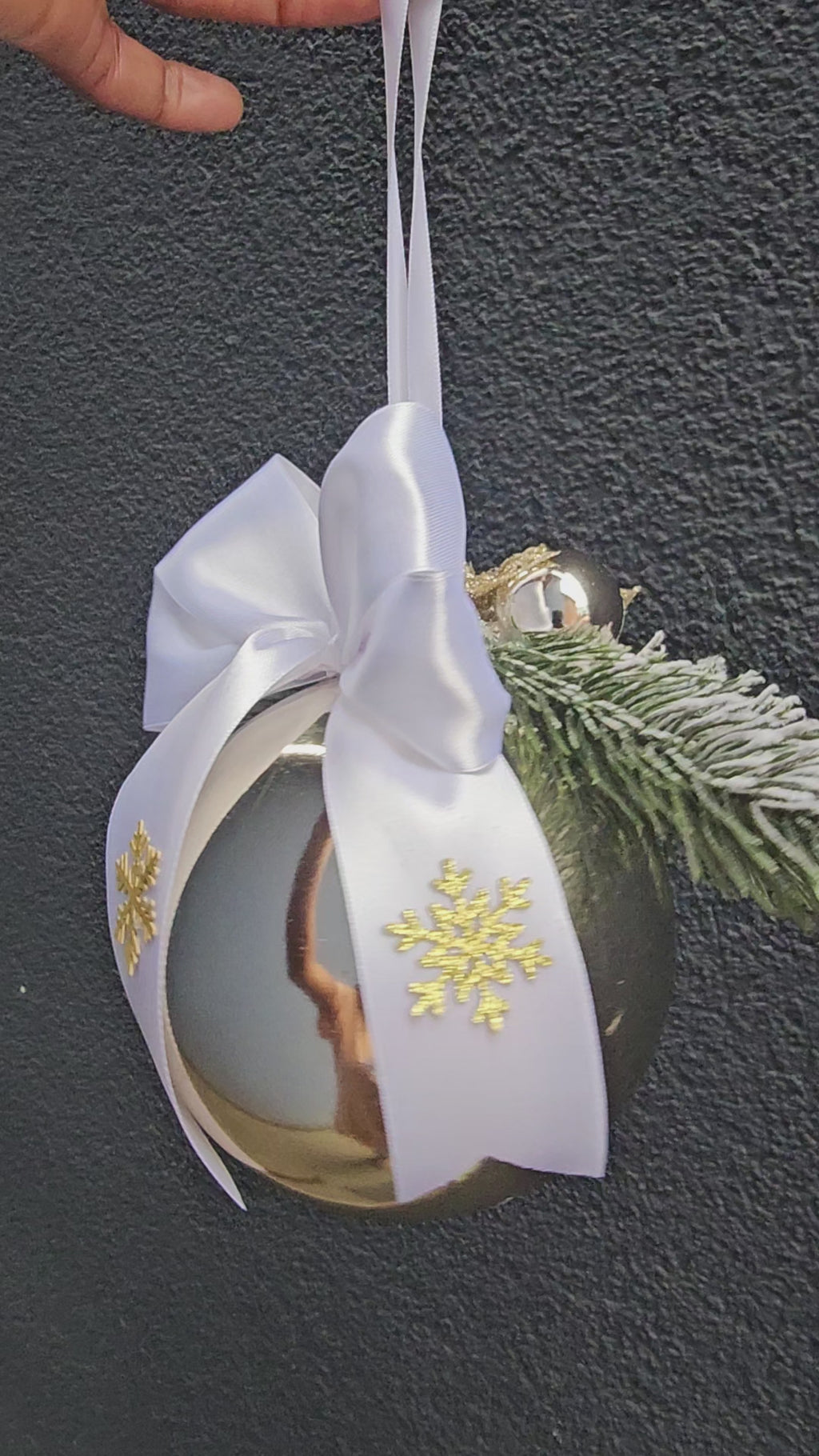 Riesige, festlich geschmückte Weihnachtskugel in Gold/Mit frostigen Zweigen und Schleife.